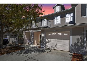 Charming townhouse exterior with a front balcony and attached garage, located in a vibrant community at 13832 Dove Wing Ct, Orlando, FL 32828