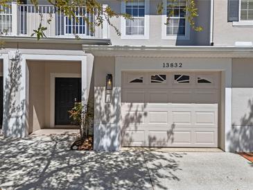 Charming townhome showcasing a convenient front entry garage and private front door entrance at 13832 Dove Wing Ct, Orlando, FL 32828