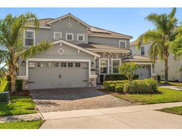 Charming two-story home featuring a three-car garage, beautifully landscaped yard, and well-maintained exterior at 1395 Olympic Club Blvd, Champions Gate, FL 33896