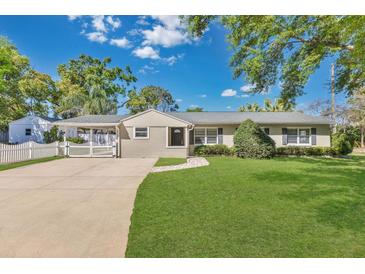 Charming single-story home featuring a manicured lawn, mature trees, and inviting curb appeal on a sunny day at 3000 Amherst Ave, Orlando, FL 32804