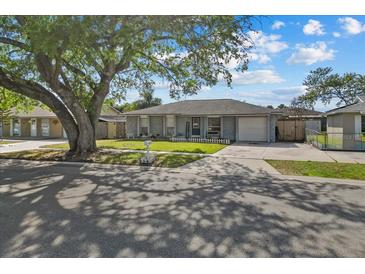 Charming single-story home with a well-maintained lawn and mature tree providing shade at 3840 Cedarwaxwing Ave, Orlando, FL 32822