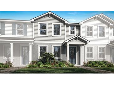 Charming two-story townhome with gray siding, manicured lawn, and colorful flower beds enhancing curb appeal at 4200 Sadler Rd, Apopka, FL 32712