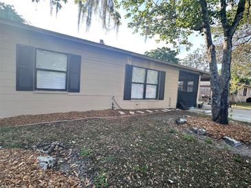 A single-story home with neutral siding, dark shutters, and minimal landscaping for a clean, simple exterior at 5298 Rose Ave, Orlando, FL 32810