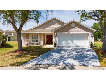 Charming single-story home featuring an attached two-car garage and a well-manicured front yard at 654 Chadbury Way, Kissimmee, FL 34744