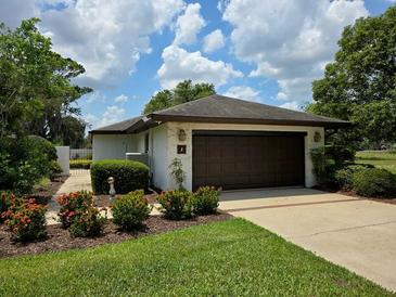 Attached garage with meticulously landscaped lawn and garden creates a welcoming curb appeal at 1 Huntley Ct, Haines City, FL 33844