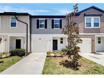 Charming two-story townhome featuring a one car garage and professionally landscaped yard at 1112 Merrill St, Davenport, FL 33837