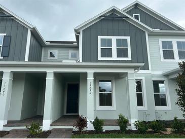Inviting two-story townhouse with a covered front porch and Craftsman-style architectural details at 13536 Autumn Harvest Ave, Winter Garden, FL 34787