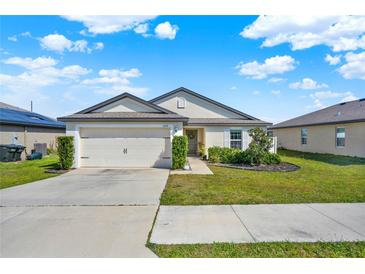 Charming single-story home with a well-manicured lawn and two car garage at 1579 Swan Lake Cir, Dundee, FL 33838