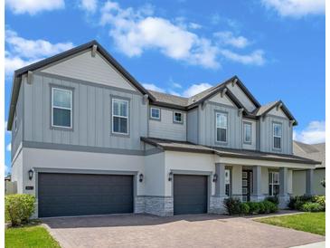 Charming two-story home featuring a three-car garage, brick driveway and beautifully landscaped yard at 2011 Soaring Oak Way, Winter Park, FL 32792