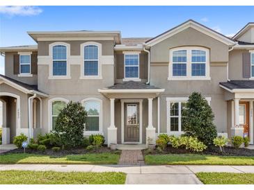 Inviting townhome with a well-maintained front yard and charming architectural details at 2694 Giardino Loop, Kissimmee, FL 34741