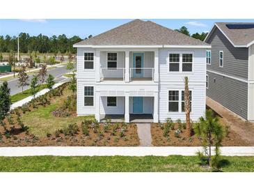 Charming two-story home with a covered porch and balcony and a lovely landscaped front yard at 3002 Voyager Ave, St Cloud, FL 34771