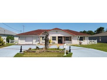 Charming single-story home featuring a red tile roof and stucco exterior, with a well-manicured front yard at 39 Fellowship Dr, Palm Coast, FL 32137