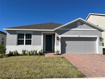 Charming single-story home features a well-maintained lawn, a brick driveway, and a neutral color scheme at 618 Duke Dr, Haines City, FL 33844