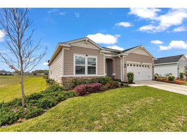 Charming single-story home with a two-car garage, lovely landscaping, and manicured lawn on a sunny day at 7536 Sw 77Th Ave, Ocala, FL 34481