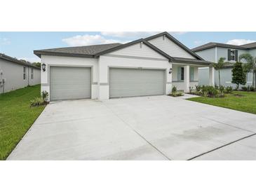Charming single-story home with a three-car garage and a well-maintained front yard at 2352 Citrus Bloom Dr, Bartow, FL 33830