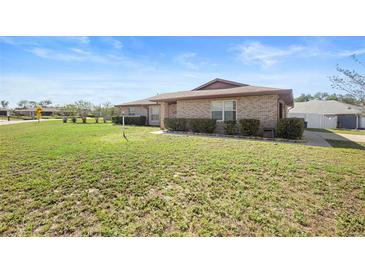 Charming single-story brick home featuring manicured front yard landscaping at 947 N Atmore Cir, Deltona, FL 32725