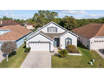 Charming one-story home featuring a well-manicured lawn, attached two-car garage, and inviting curb appeal at 1056 Royal Saint George Dr, Orlando, FL 32828