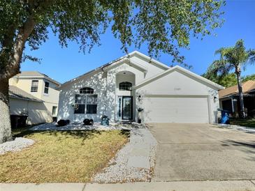 Charming single-story home featuring a well-manicured lawn, stone pathway, and attached two-car garage at 1309 Rebecca Dr, Haines City, FL 33844
