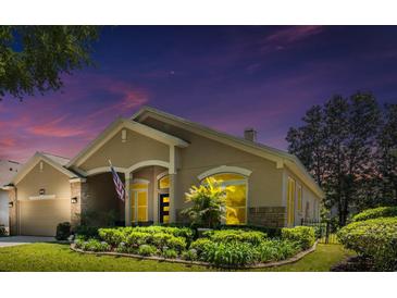 Charming single-story home with lush landscaping, beautiful lawn, and a welcoming facade with an American flag at 1450 Chessington Cir, Lake Mary, FL 32746