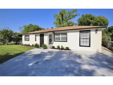 Charming home featuring a newer driveway, front lawn with plants and updated white exterior paint at 1475 Lowrie Ave, Orlando, FL 32805