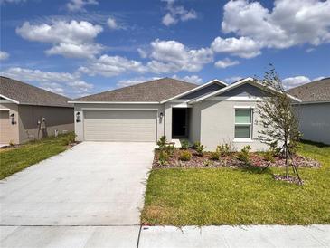 Charming single-story home with a two-car garage, landscaped yard, and welcoming entrance at 1721 Teagan Ln, Winter Haven, FL 33884