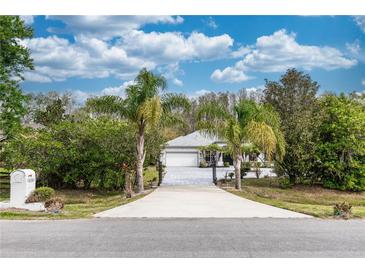 Inviting single-story home with a private driveway, a two-car garage, and mature trees under a cloudy sky at 19261 Quarterly Pkwy, Orlando, FL 32833