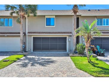 Inviting townhouse with a gray brick driveway and a one-car garage with tropical landscaping at 33 Sea Haven Dr, Ponce Inlet, FL 32127