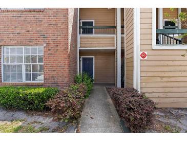 Exterior view of a two-story apartment building with brick and siding and well-maintained landscaping at 4355 Perkinshire Ln # 103, Orlando, FL 32822
