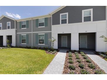 Charming two-story townhouse with well-manicured lawn and inviting facade at 977 Paradise Dr, Davenport, FL 33897