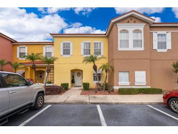 Charming, colorful townhome exterior with lush landscaping and a well-maintained front yard in a sunny neighborhood at 979 Park Terrace Cir, Kissimmee, FL 34746