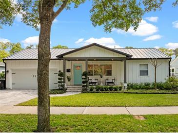 Charming exterior of home with a metal roof, landscaped lawn, and a lovely front porch sitting area at 1136 W Harvard St, Orlando, FL 32804