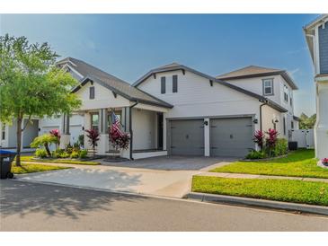 Beautiful two-story home featuring a manicured lawn, two-car garage, and inviting architecture at 15313 Lebeau Loop, Winter Garden, FL 34787