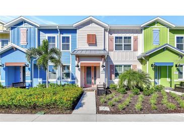 Charming townhomes featuring brightly painted exteriors with manicured landscaping and welcoming front porches at 3205 Caribbean Soul Dr, Kissimmee, FL 34747