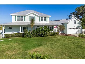 Charming two-story home featuring a lush green lawn and beautifully landscaped front yard with meticulous shrubbery at 4240 Lake Harney Cir, Geneva, FL 32732