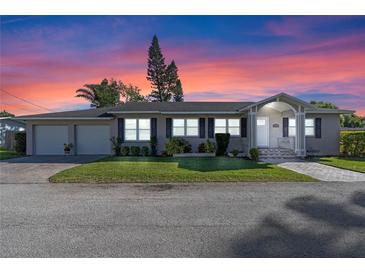 Charming single-story home featuring a well-manicured lawn, brick driveway and an attached two-car garage at 4321 Summer Ln, Orlando, FL 32804