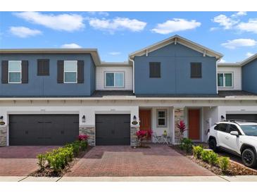 Charming exterior view of two-story townhomes with brick driveway and gray garages at 4839 Jackstaff Way, Oviedo, FL 32765