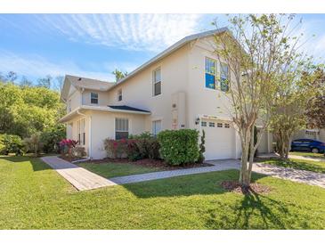 Charming townhouse with a two-car garage, manicured lawn, and lovely landscaping at 5565 Gelato Dr, Orlando, FL 32829