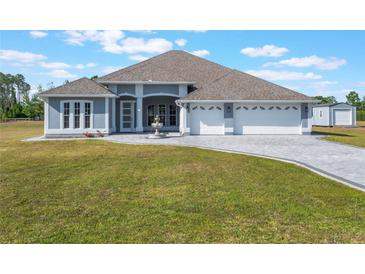 Charming single-story home featuring a three-car garage, paved driveway and a well-manicured lawn at 6607 Whispering Pines Rd, Orlando, FL 32824