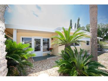 Charming home featuring tropical landscaping, a white trim, and neutral yellow siding at 726 Viking Ave, Tavares, FL 32778