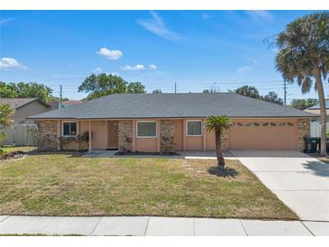 Charming single-story home featuring a tidy lawn and a two-car garage, all under a sunny blue sky at 8720 Larwin Ln, Orlando, FL 32817