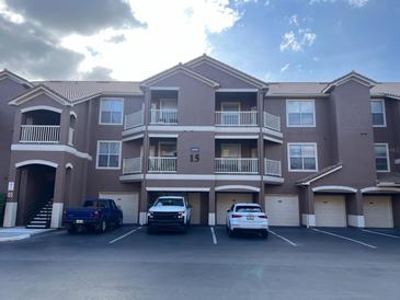 Three-story condo building shows parking with attached garages and individual unit balconies at 8849 Villa View Cir # 3, Orlando, FL 32821