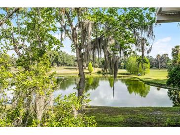 Scenic golf course view featuring a serene pond and lush green fairways, under a bright, sunny sky at 150 Golfside Cir, Sanford, FL 32773