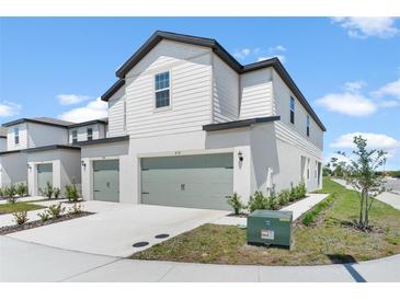 Attractive townhouse with a two-car garage, green space, and a clean, modern aesthetic at 818 Poppy Ln, Dundee, FL 33838