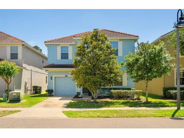 Charming two-story home with a well-maintained lawn, mature trees, and a two-car garage at 8944 Sugar Palm Rd, Kissimmee, FL 34747