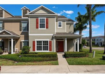 Inviting townhouse with red shutters, manicured landscaping, and a charming front porch at 1197 Tallow Rd, Apopka, FL 32703