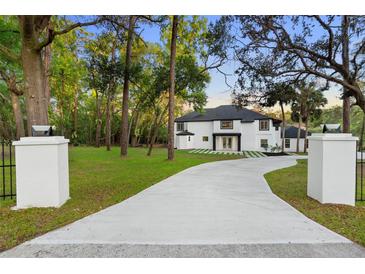Stunning two-story home with a modern design, featuring a long driveway and lush greenery at 305 Sweetwater Club Cir, Longwood, FL 32779