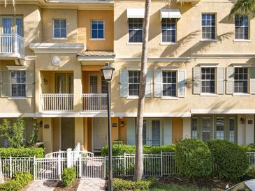 Charming townhome with white picket fence, front balcony and neutral stucco color at 728 Greybull Run, Lake Mary, FL 32746