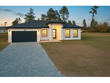 Charming single-story home with a modern design, dark gray accents, and a well-manicured lawn at 16697 Sw 23Rd Avenue Rd, Ocala, FL 34473