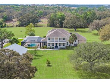 Expansive two-story home with a screened pool and sprawling green lawn at 17726 Dangler Rd, Winter Garden, FL 34787