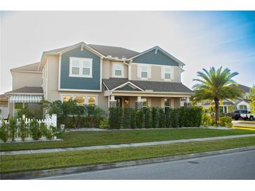 Charming two-story home boasts manicured lawn, lush landscaping, and a welcoming covered front porch at 2260 Rapollo Dr, Kissimmee, FL 34741